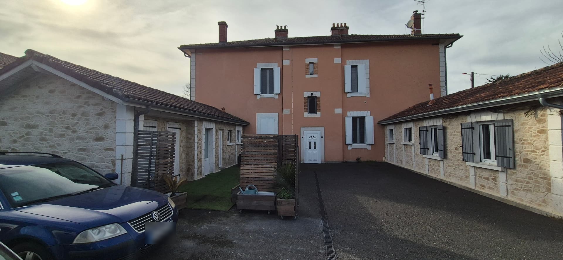 Vue d'ensemble des deux bâtiments après travaux, harmonie retrouvée entre la façade en imitation pierre et le corps de ferme ancien — PierreInnovRénov